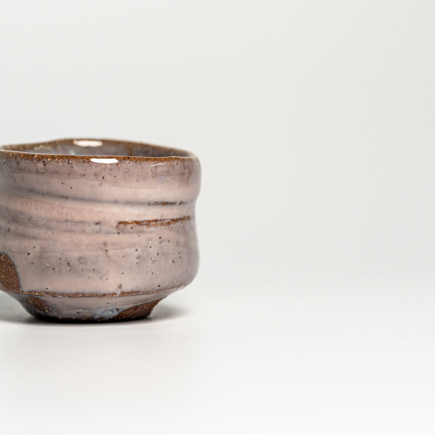 A pink Hagi yaki sake cup on a white background