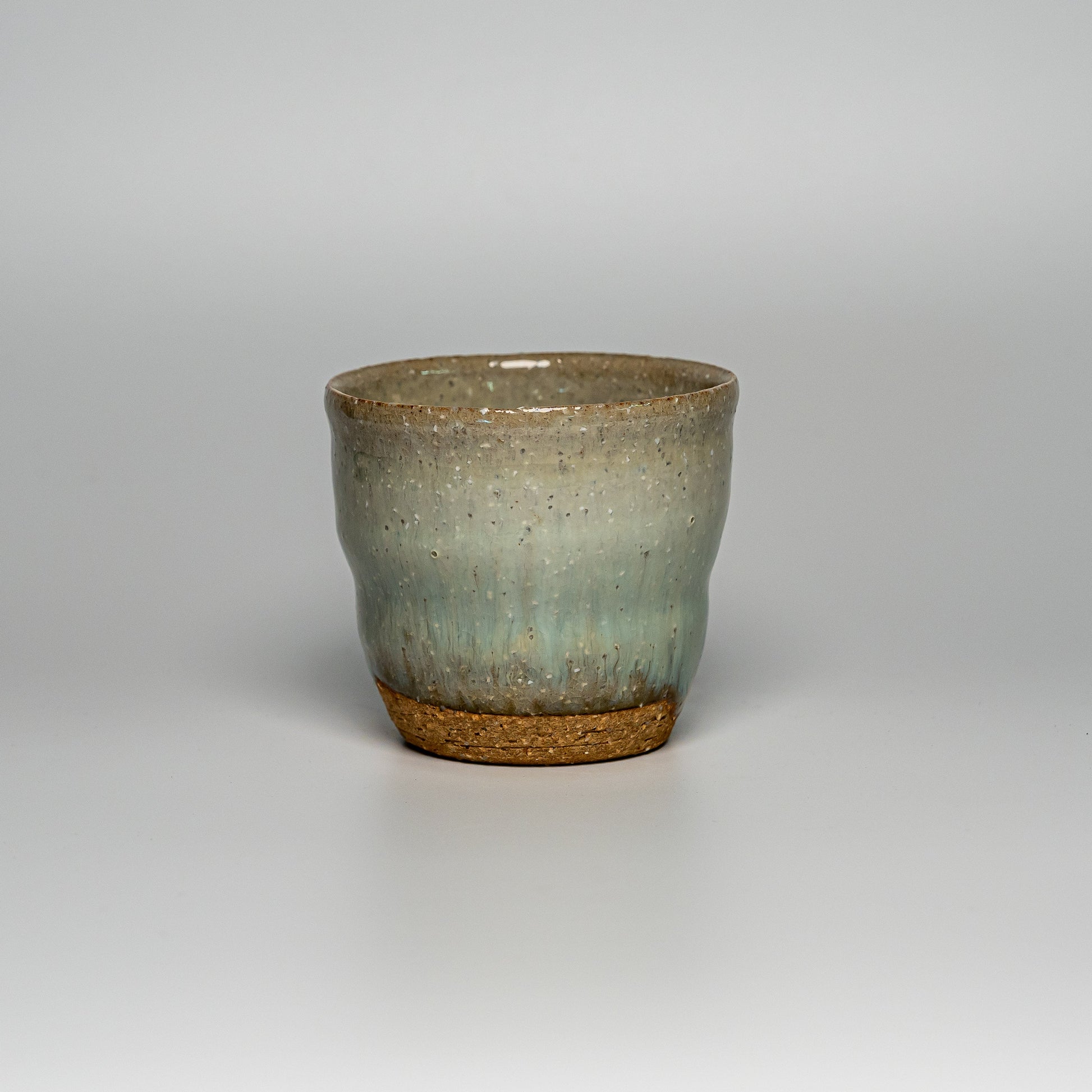 A green Hagi yaki shochu cup on a white background