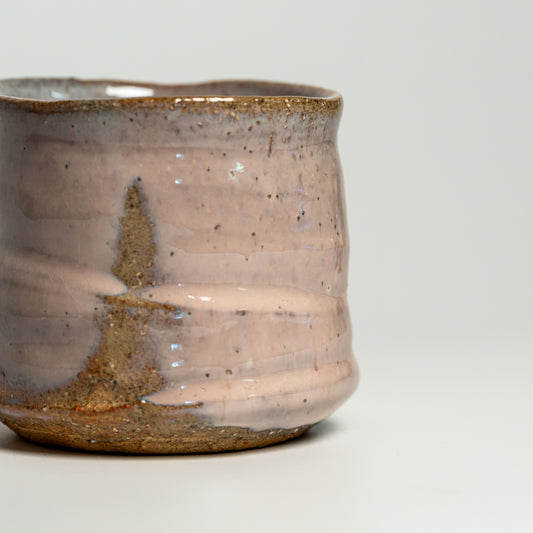 A close up of a pink Hagi yaki shochu cup on a white background