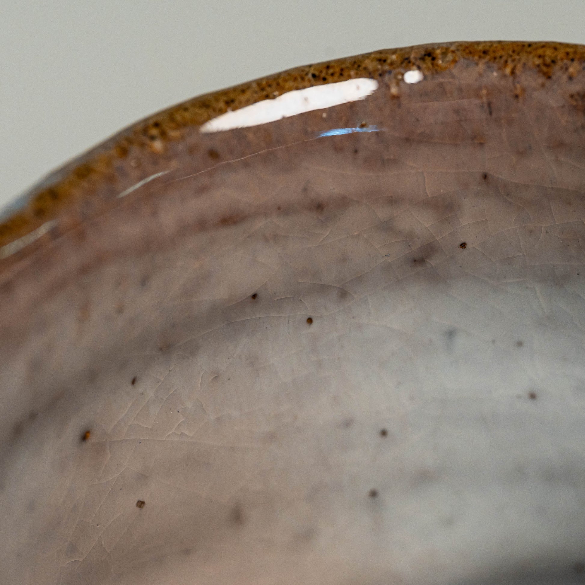 A close up of the inside a pink Hagi yaki shochu cup on a white background