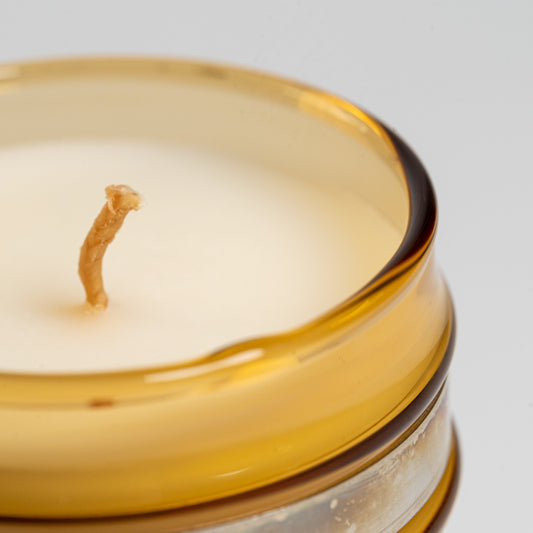Close up of a Cul de Sac hiba wood candle in a glass jar on a white background