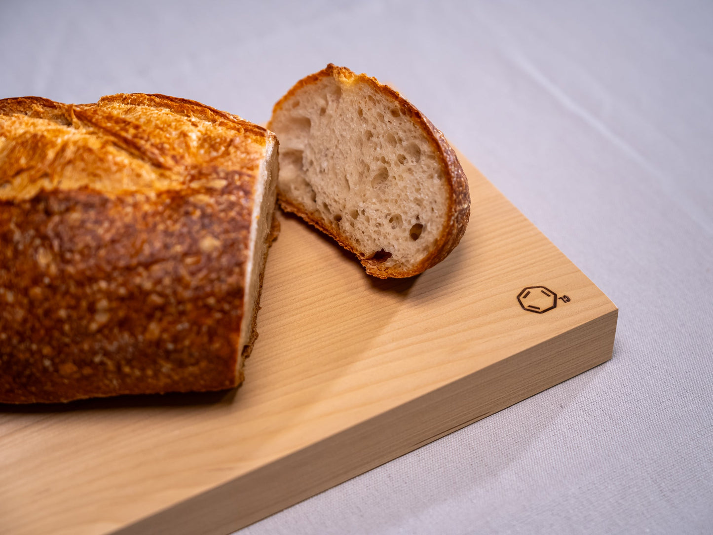 Cul de Sac's hiba wood chopping board with a sliced load of bread