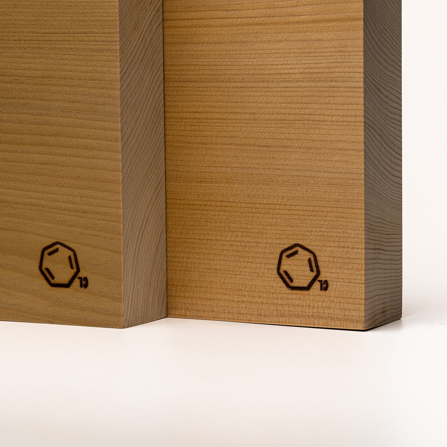 A close up of two Cul de Sac hiba wood chopping boards on a white background