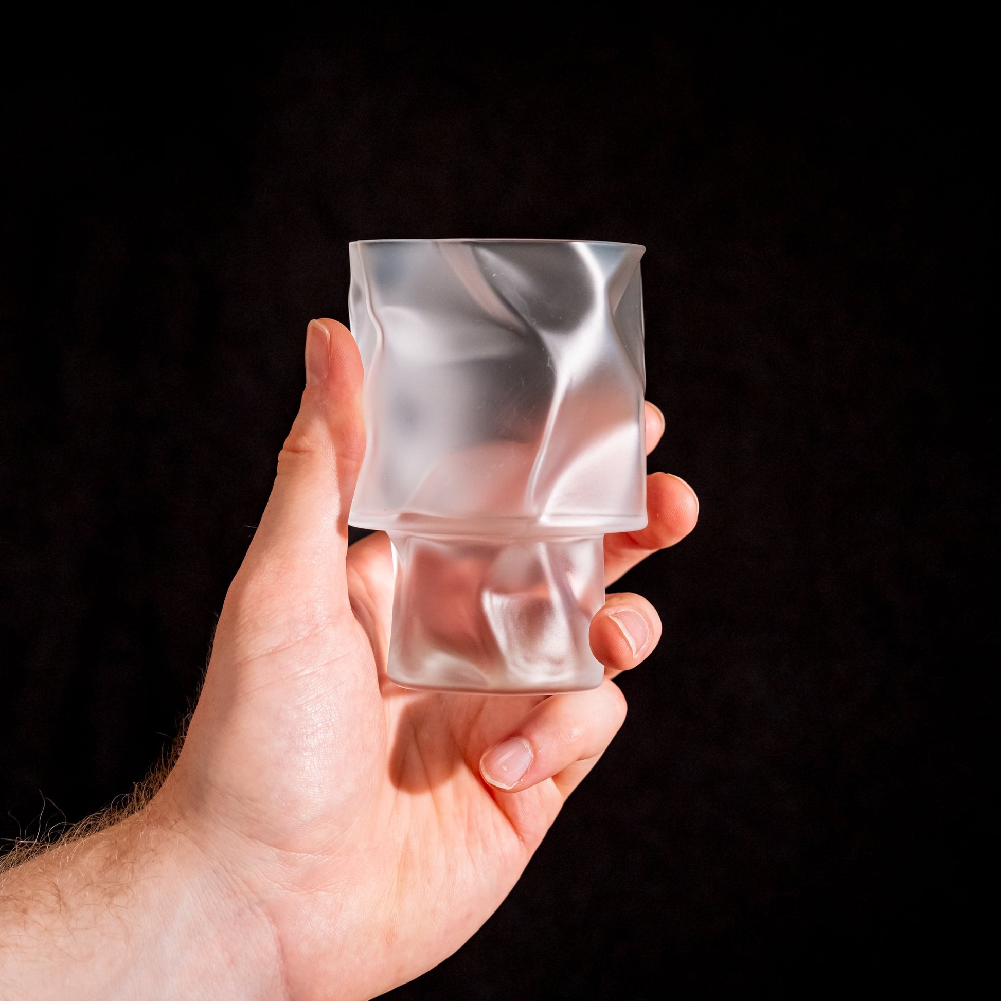 A crumpled cocktail glass by Kimura Glass held in hand