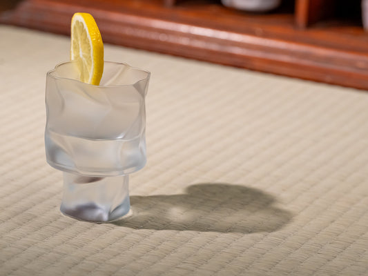 A crumpled cocktail glass by Kimura Glass on a tatami mat