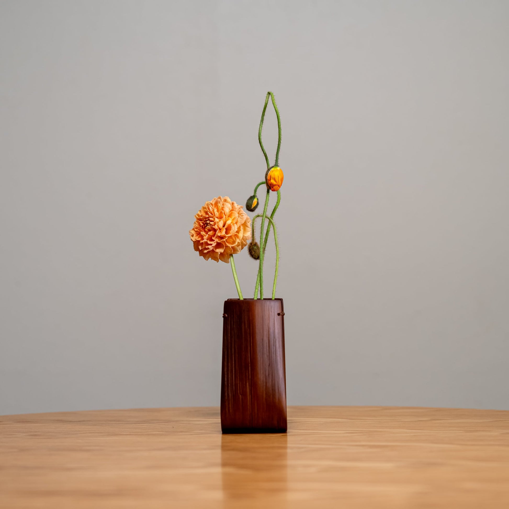 A Japanese bamboo vase with an ikebana inspired flower arrangement