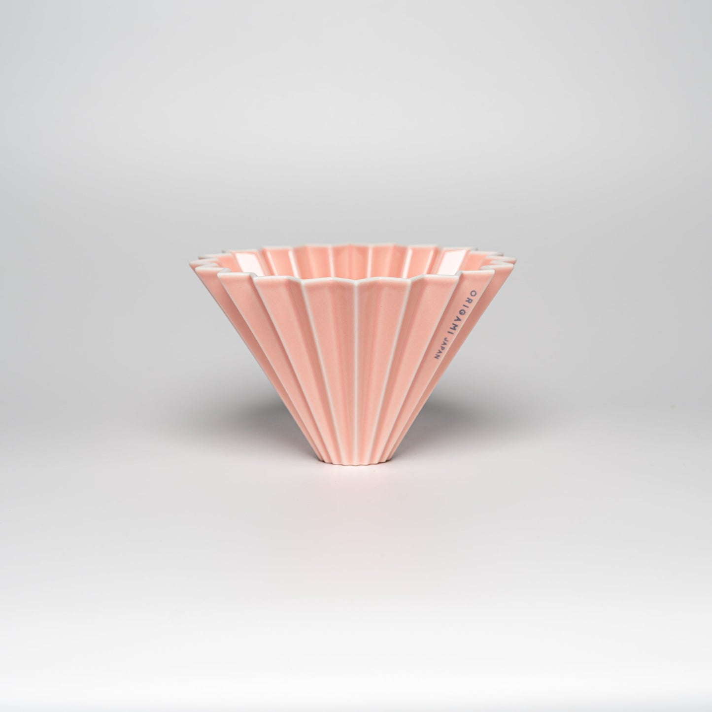 A matte pink ORIGAMI coffee dripper on a white background