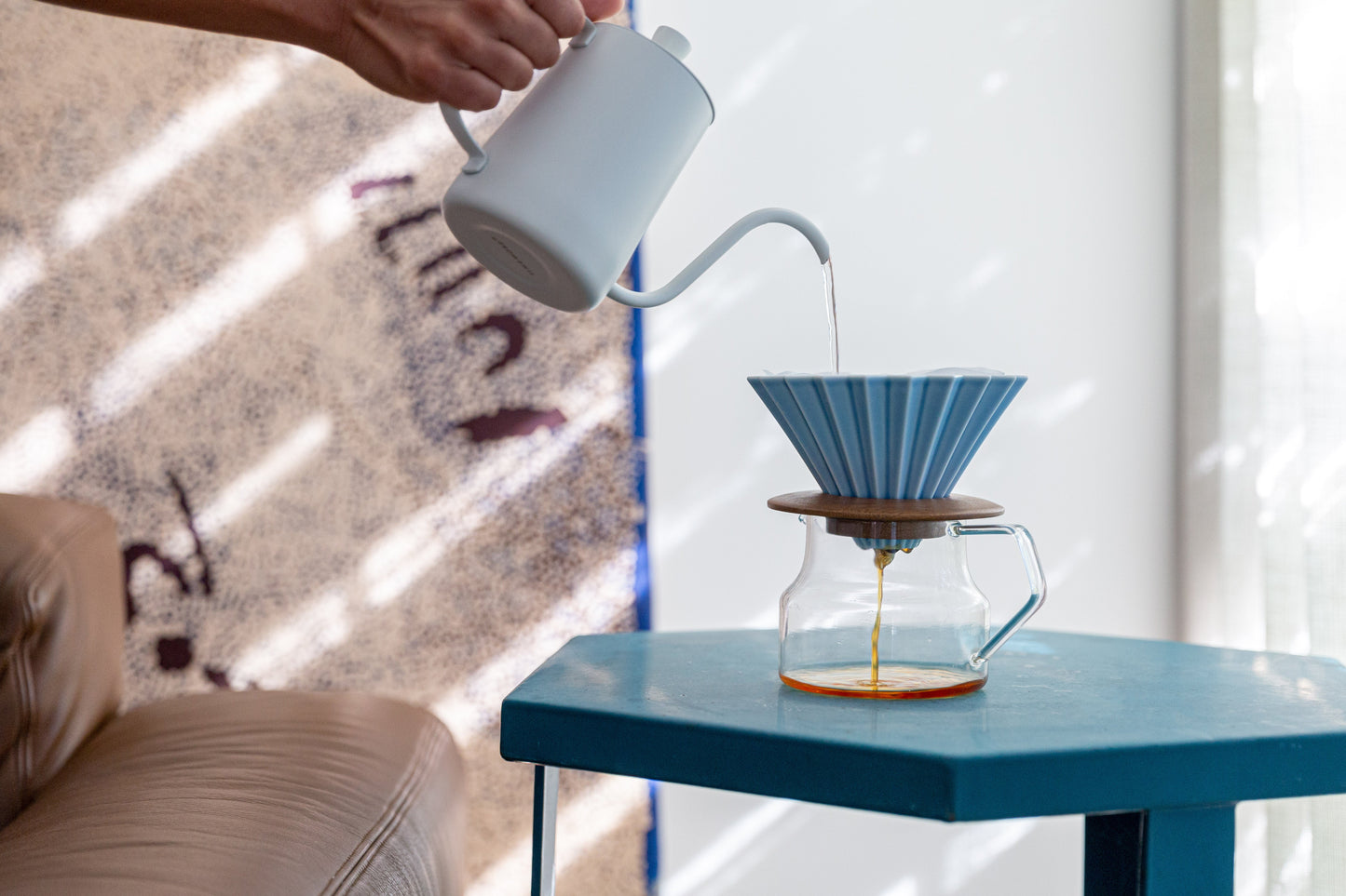 A blue ORIGAMI coffee dripper brewing coffee at home