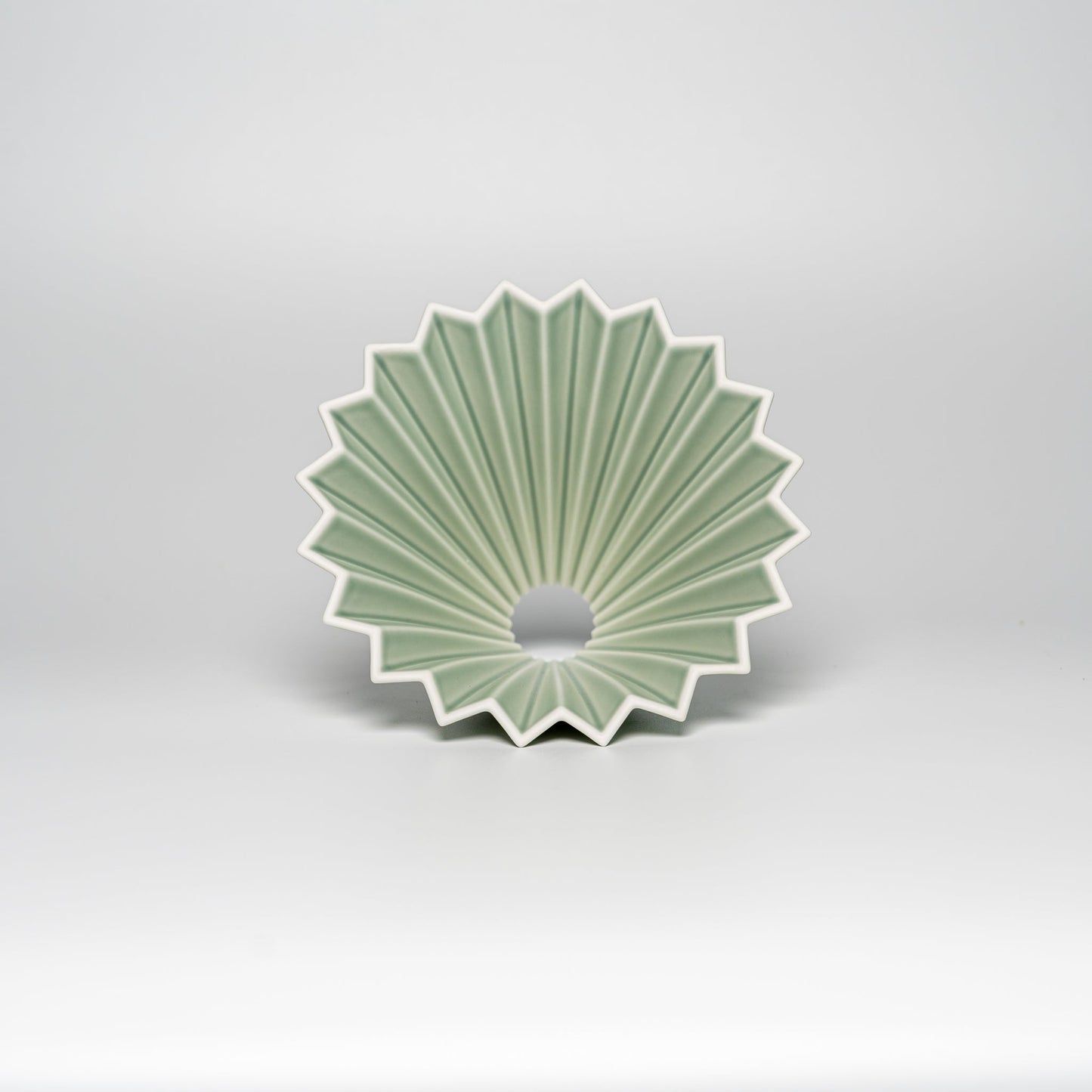 A matte green ORIGAMI coffee dripper on a white background