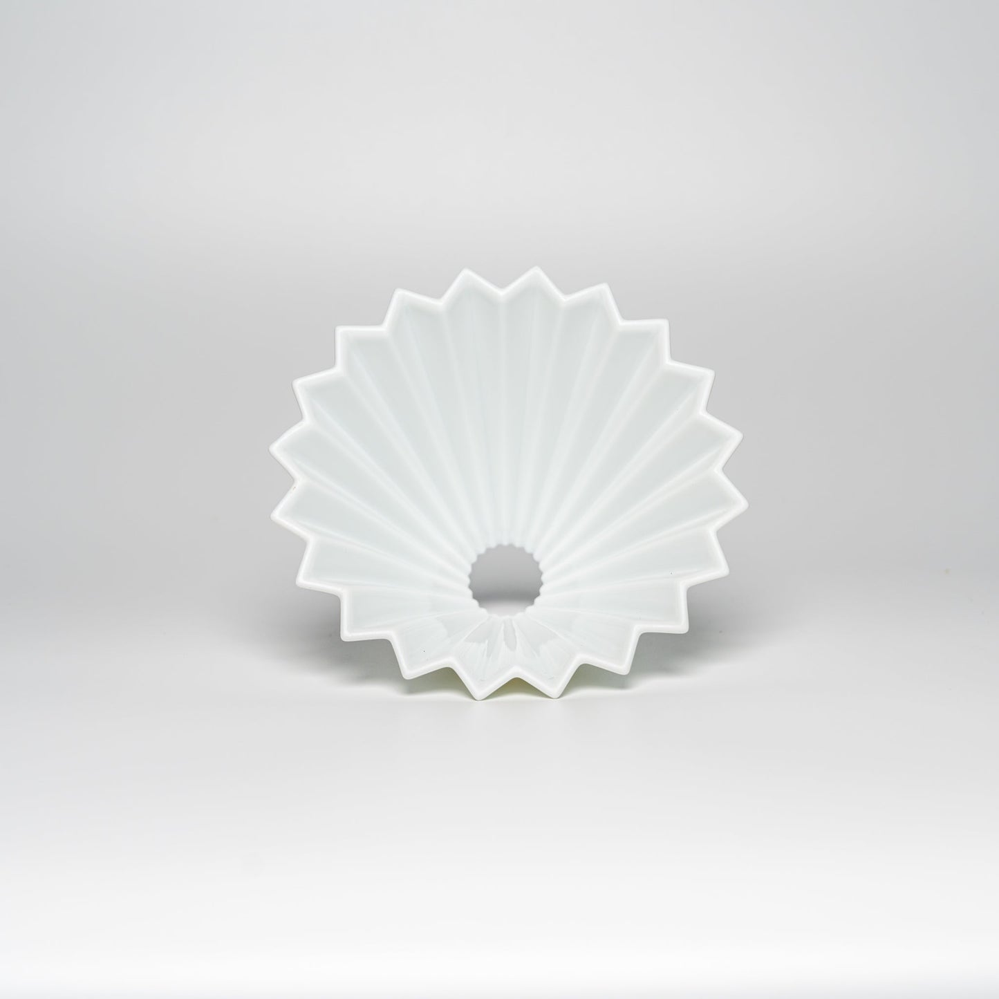 A white ORIGAMI coffee dripper on a white background