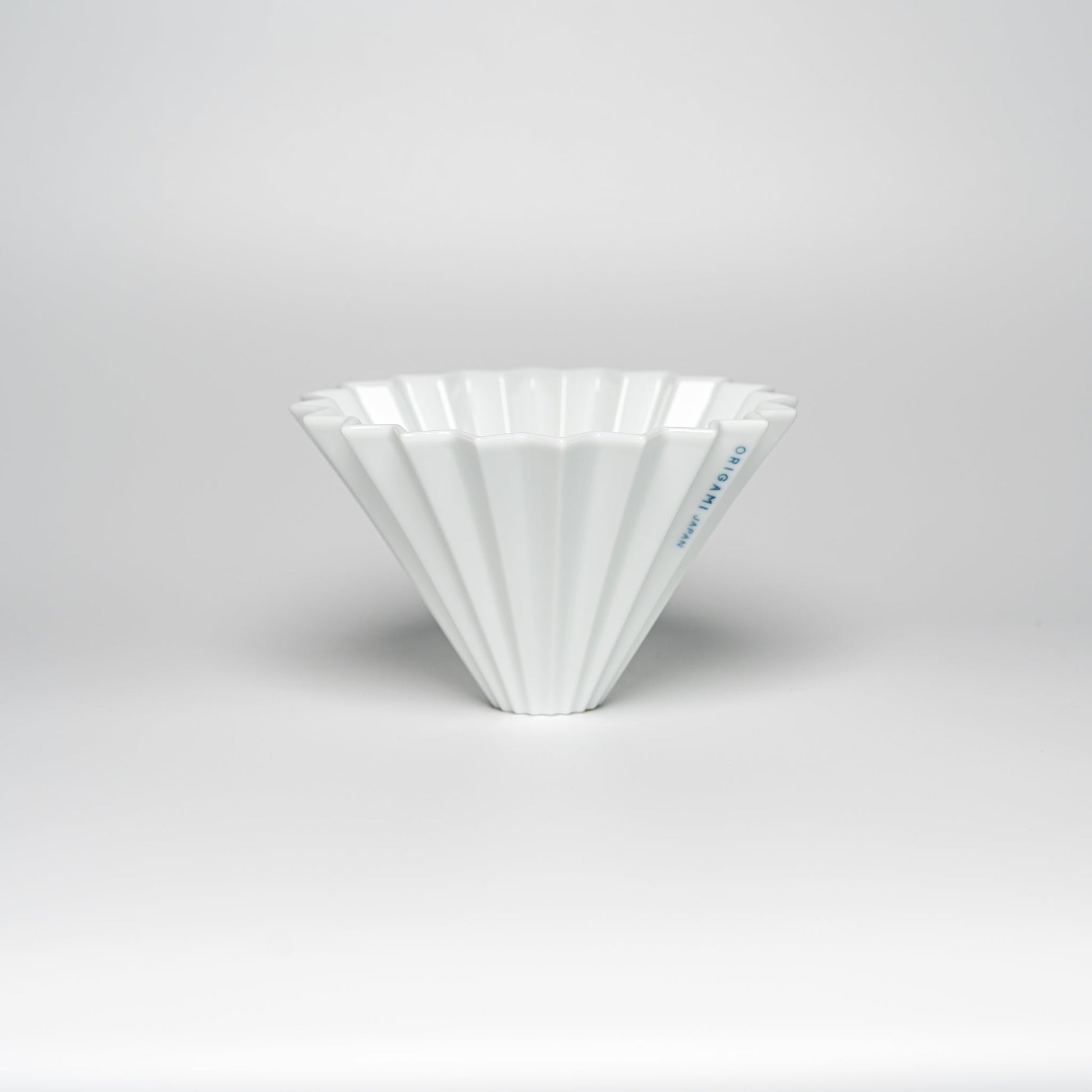 A white ORIGAMI coffee dripper on a white background