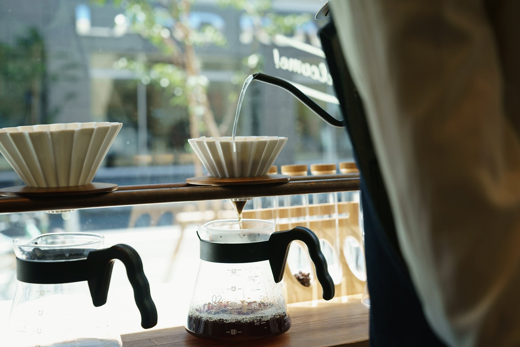 A white ORIGAMI coffee dripper brewing coffee in a cafe in Japan