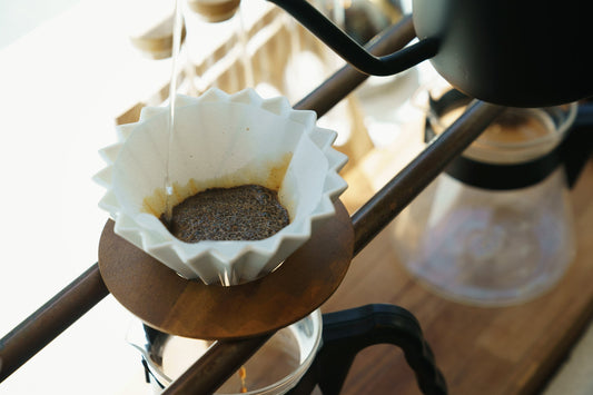 A white ORIGAMI coffee dripper brewing coffee in a cafe in Japan