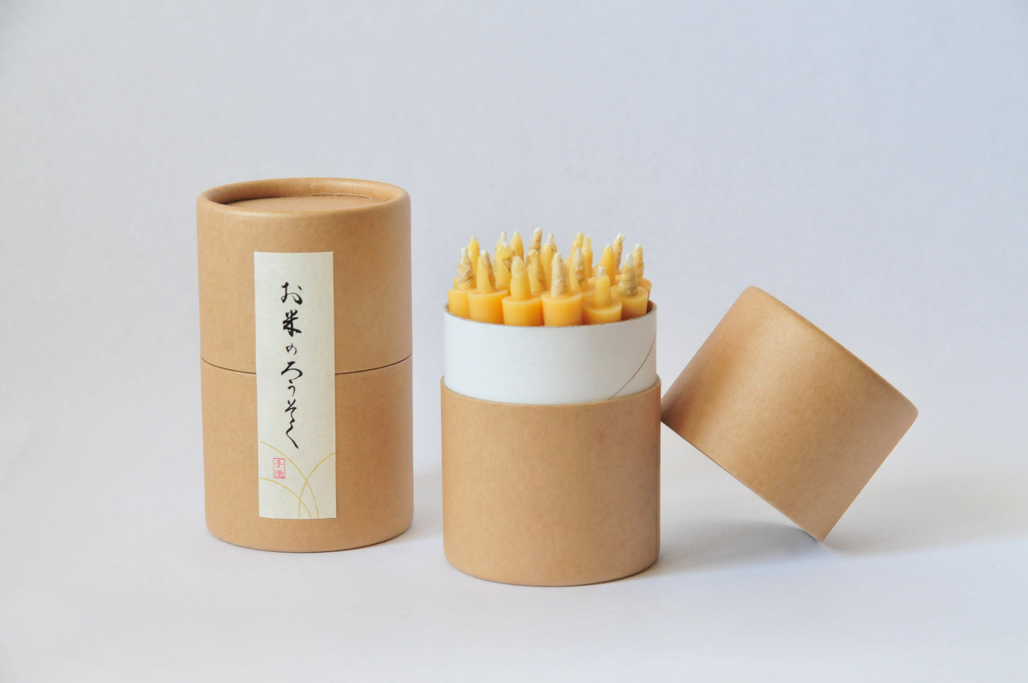 An open box of rice wax candles on a white background