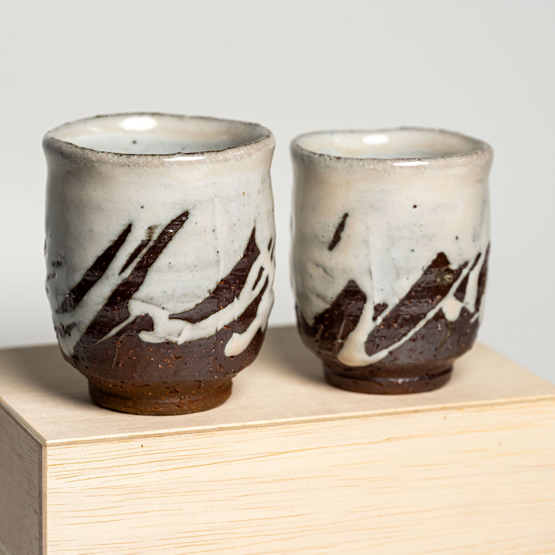 White Hagi yaki teacups on their wooden box on a white background