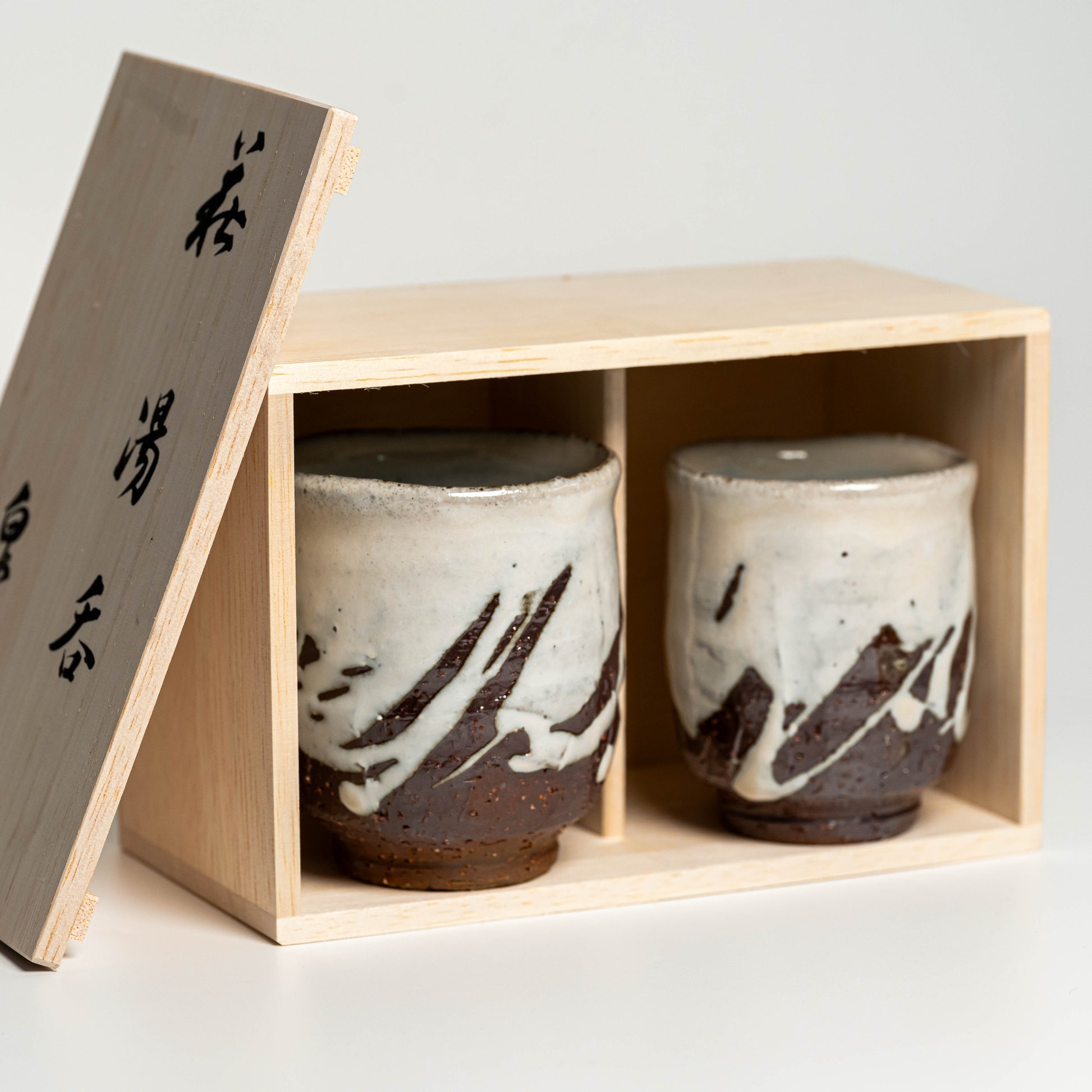 White Hagi yaki teacups in their wooden box on a white background