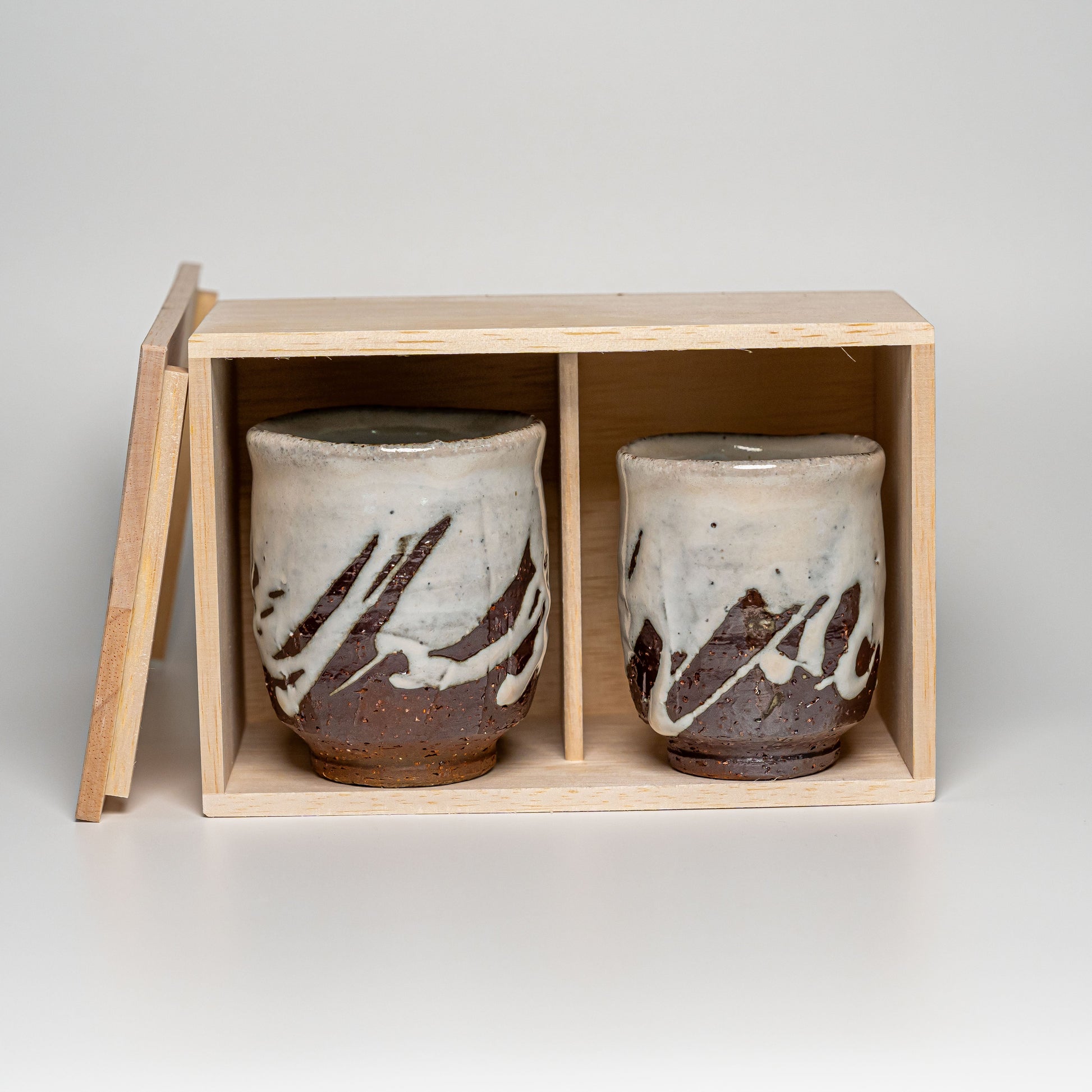 White Hagi yaki teacups in their wooden box on a white background