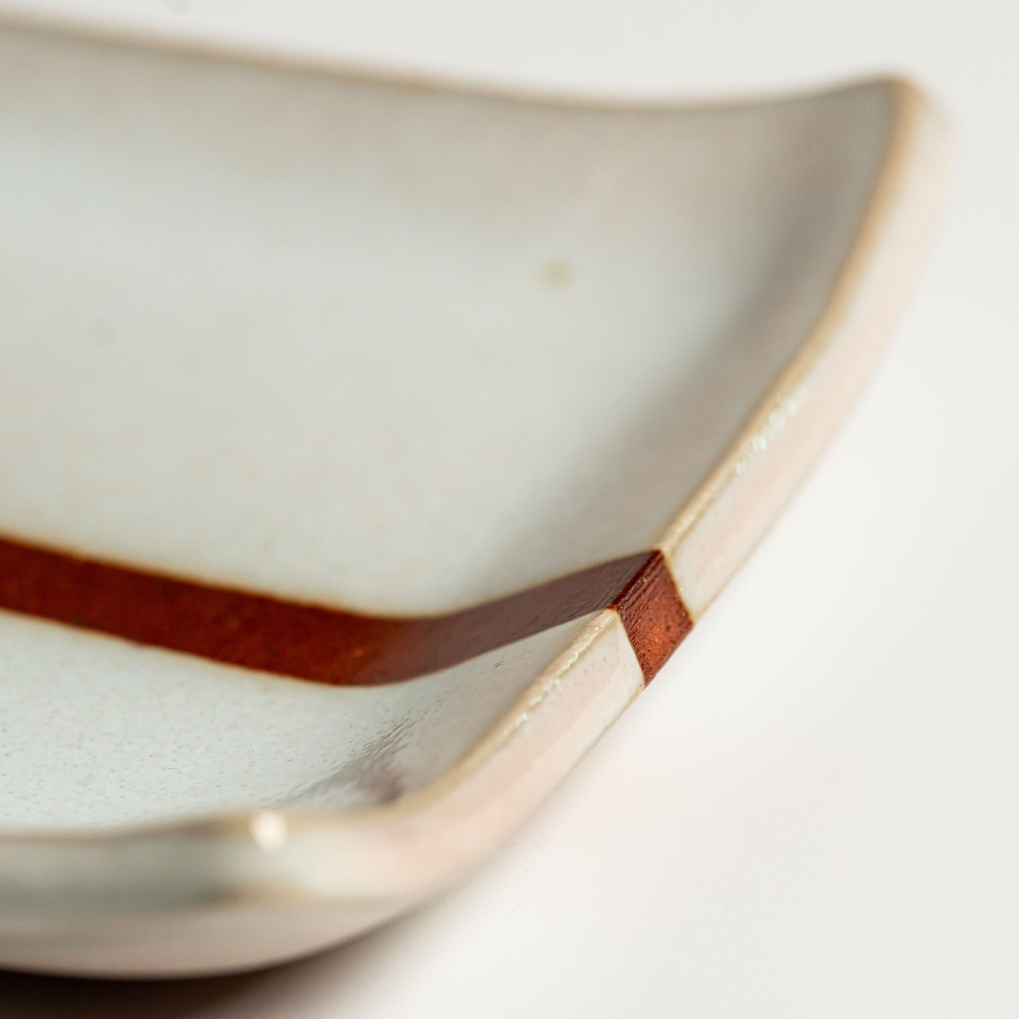 A close up of a white Hagi yaki plate on a white background