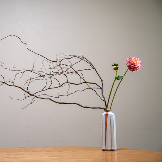 A Japanese ceramic vase with an ikebana inspired flower arrangement