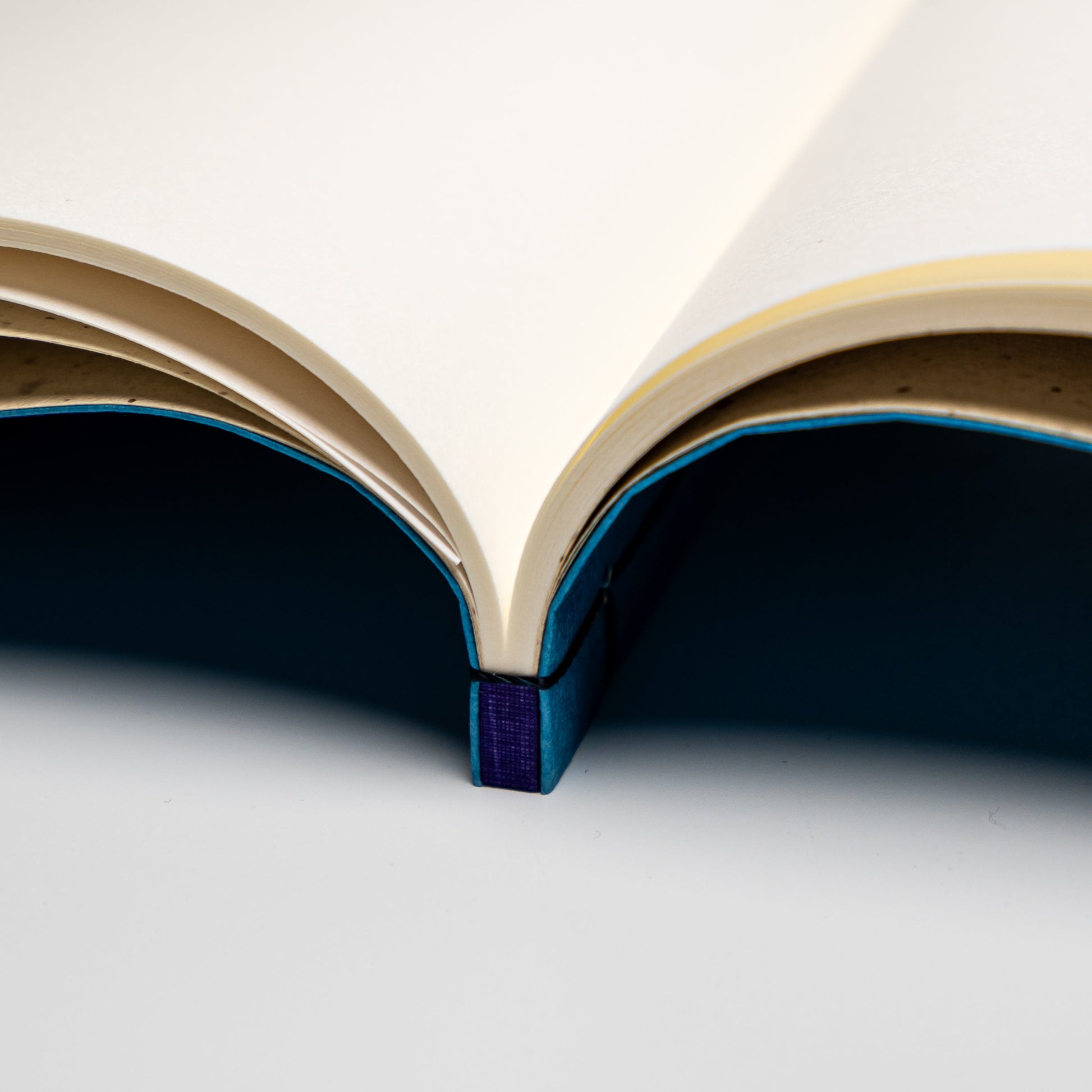 A close up of an indigo Awagami Factory washi paper Watoji Notebook on a white background