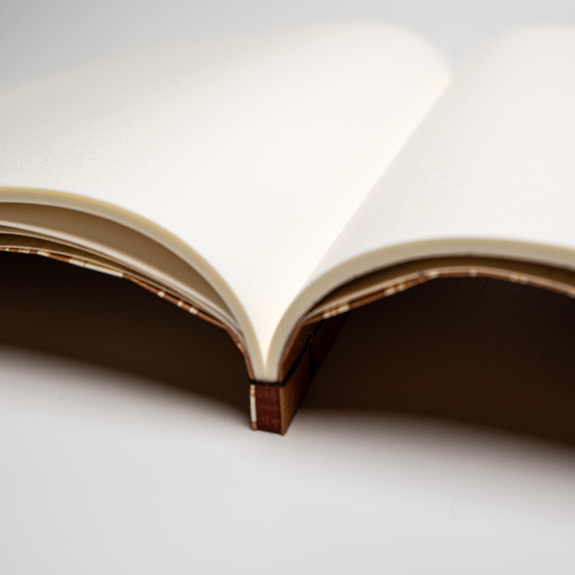 A close up of a striped Awagami Factory washi paper Watoji Notebook on a white background